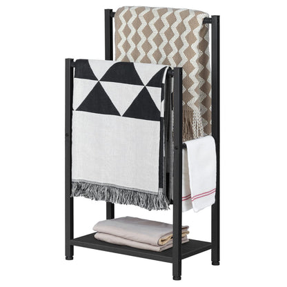 Black metal blanket ladder with folded blankets on a white background