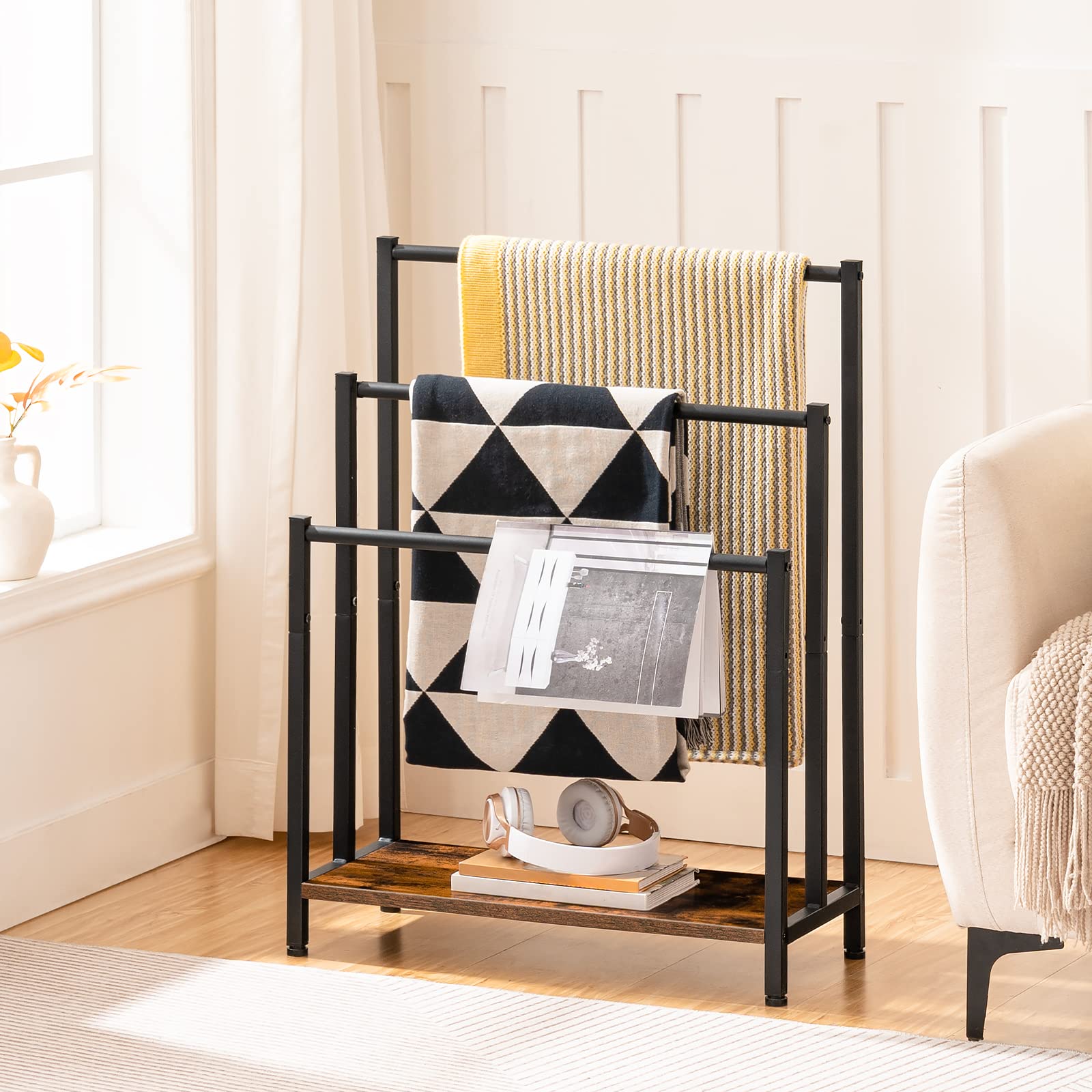 Black metal towel rack with towels and magazines in a bright room.