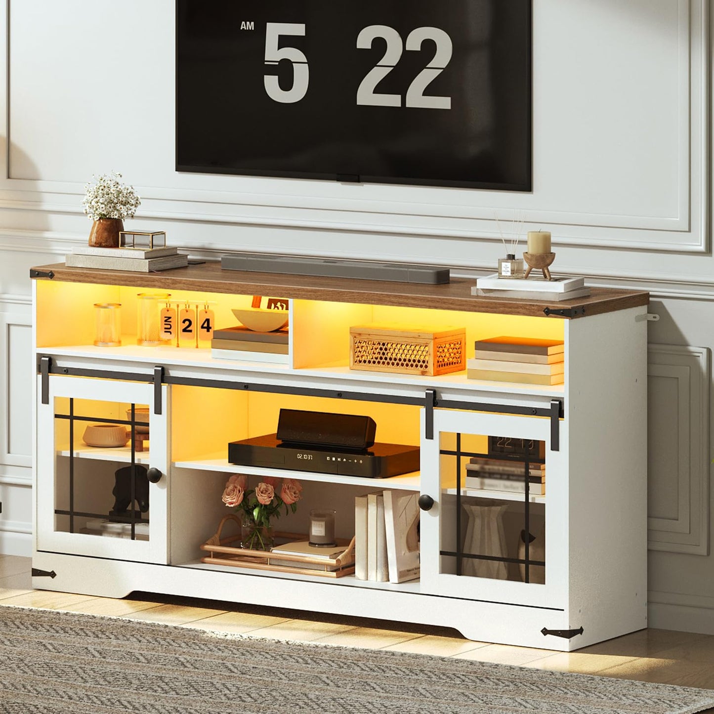 Modern entertainment console with glass doors and wooden top in a living room setting.