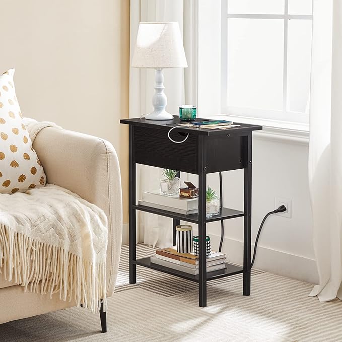 Black side table with shelves next to a beige armchair in a living room.