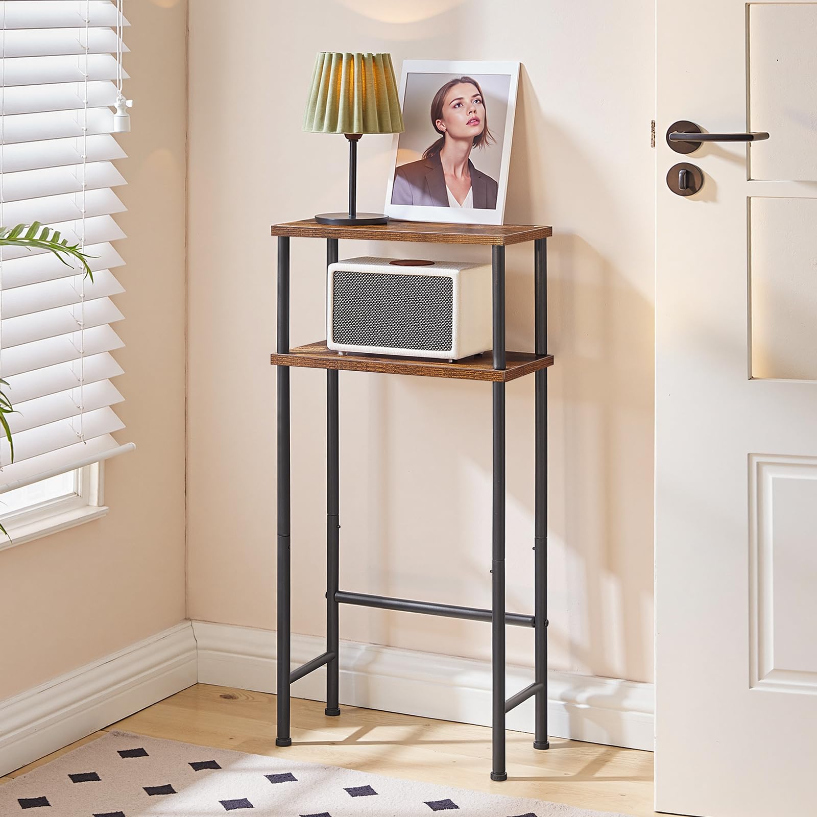 Tall narrow wooden shelf with a lamp and photo frame against a beige wall.