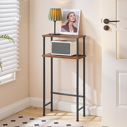 Tall narrow wooden shelf with a lamp and photo frame against a beige wall.
