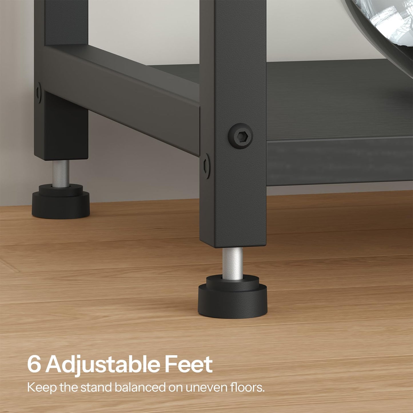 Close-up of a metal stand with adjustable feet on a wooden floor.