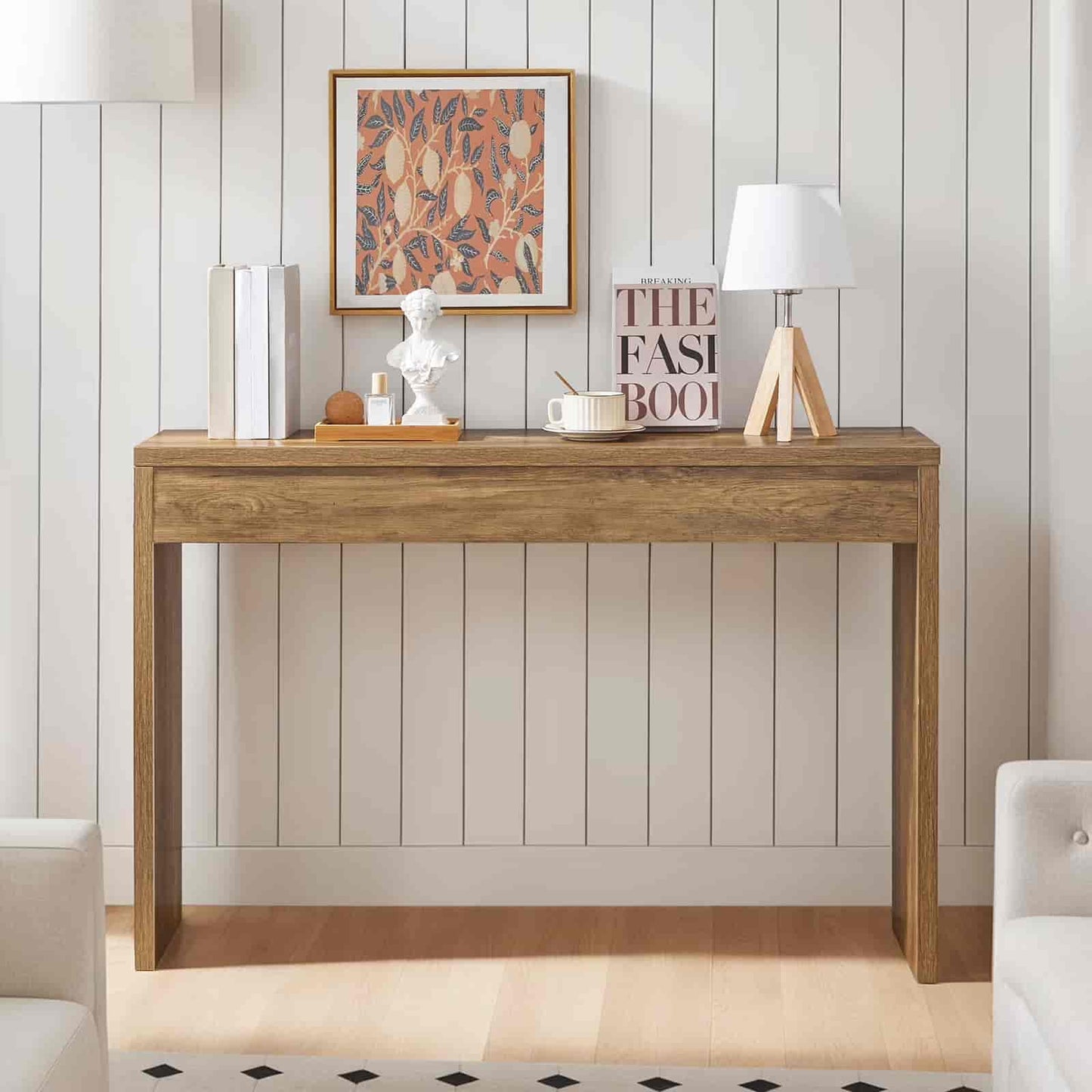 Wooden console table with decorative items against a white paneled wall.