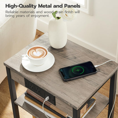 Small wooden table with a smartphone charging, a cup of coffee, and a vase on a light-colored floor.