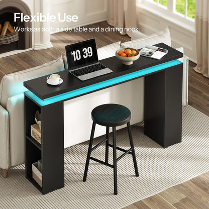 Black desk with blue LED lights in a living room setting, featuring a laptop and a bowl of fruit.