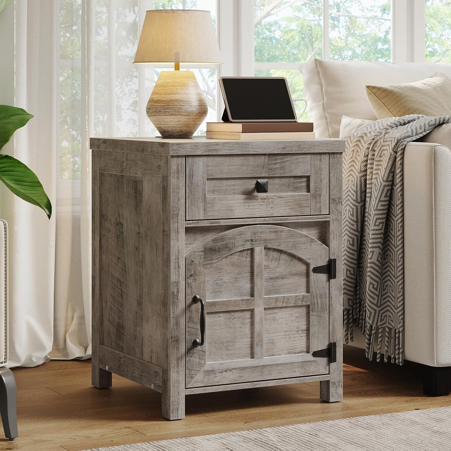 Wooden nightstand with lamp and tablet in a living room setting