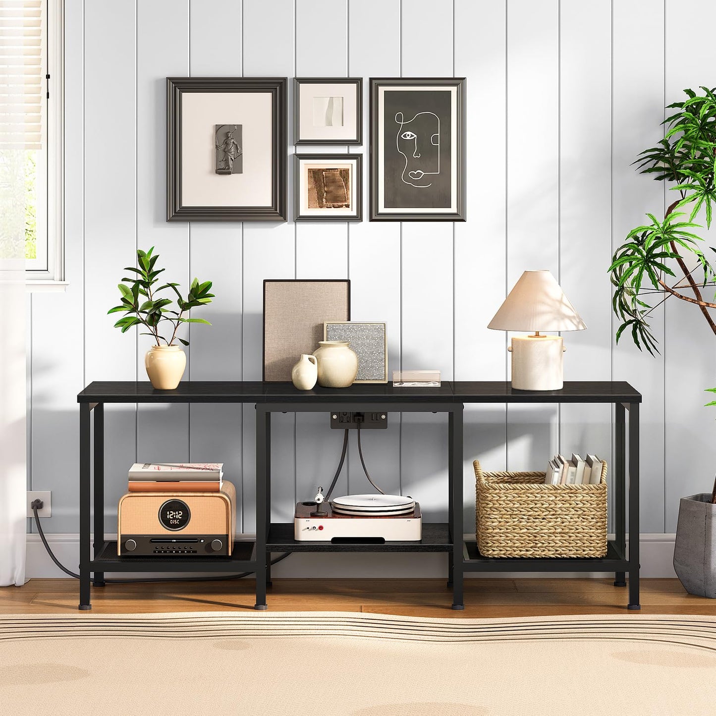 Black console table with decorative items against a white paneled wall.