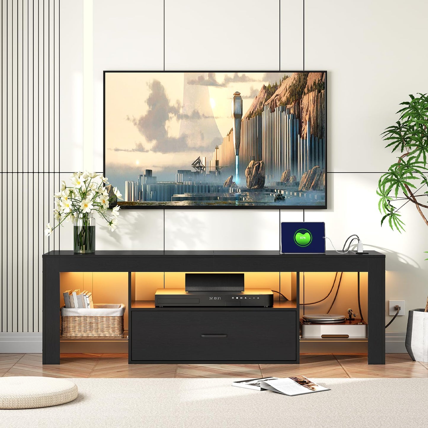 Modern black TV stand with a mounted television displaying a scenic image, in a room with decorative elements.