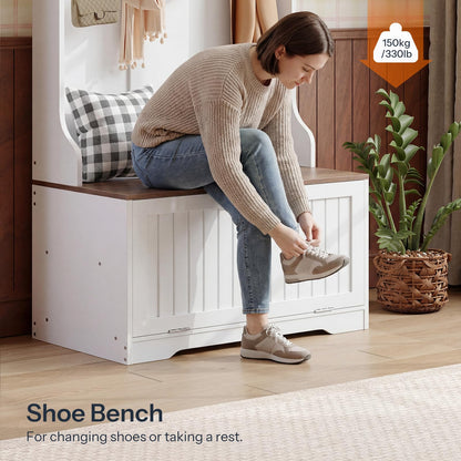 Woman sitting on a white shoe bench with wooden top, tying her shoe.