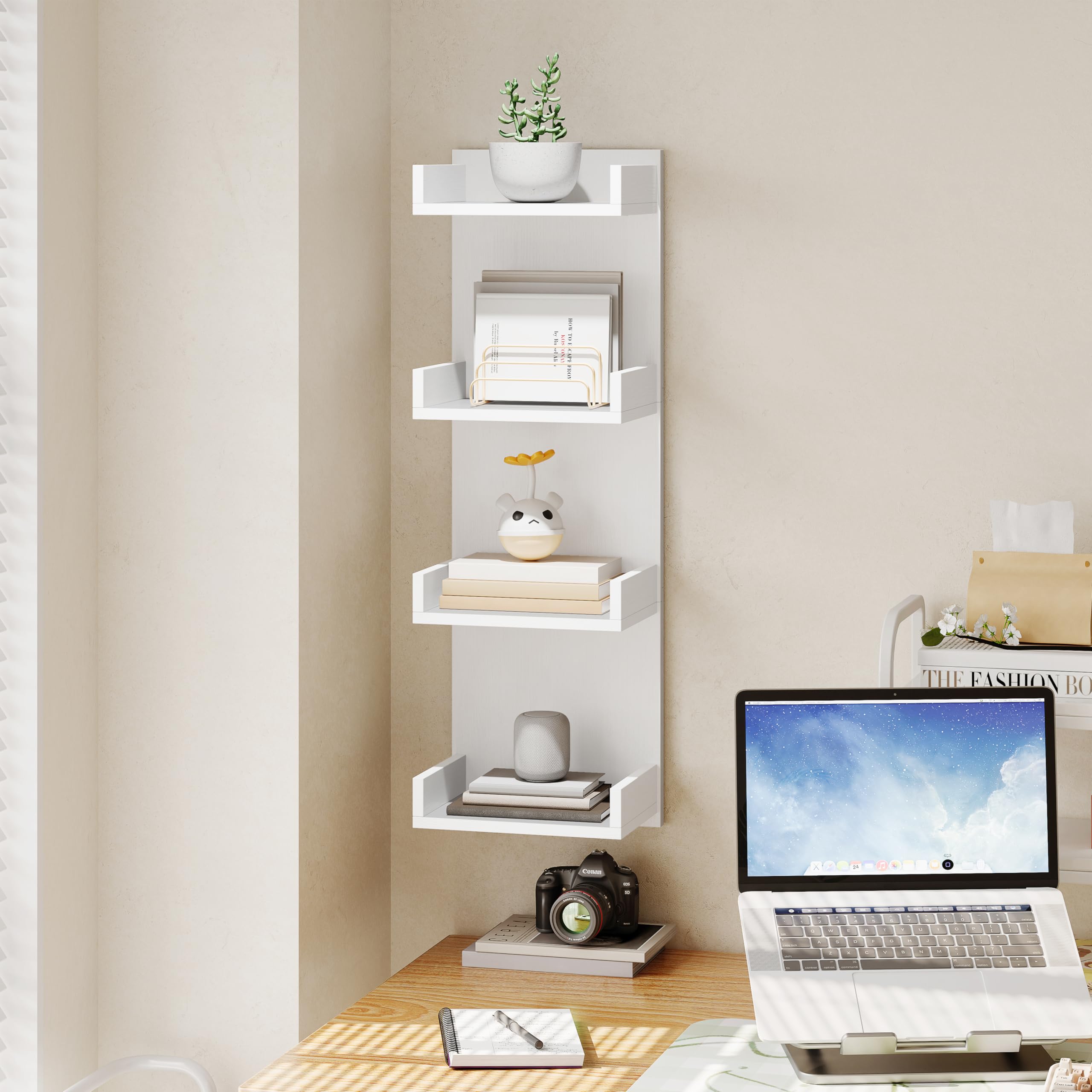 White wall shelf with decorative items and a laptop on a desk.