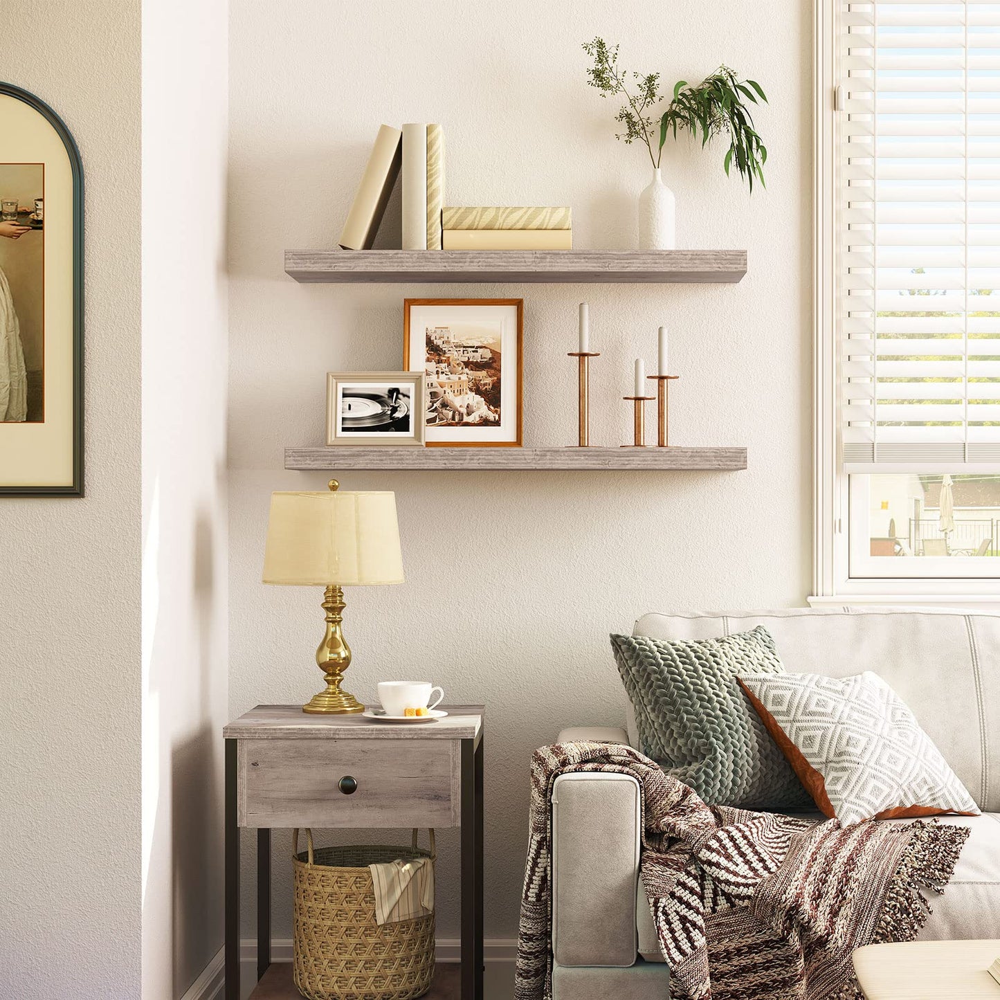 Living room with gray sofa, side table, lamp, and wall shelves.