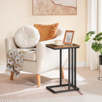 Small wooden side table next to a white armchair with cushions in a living room setting.