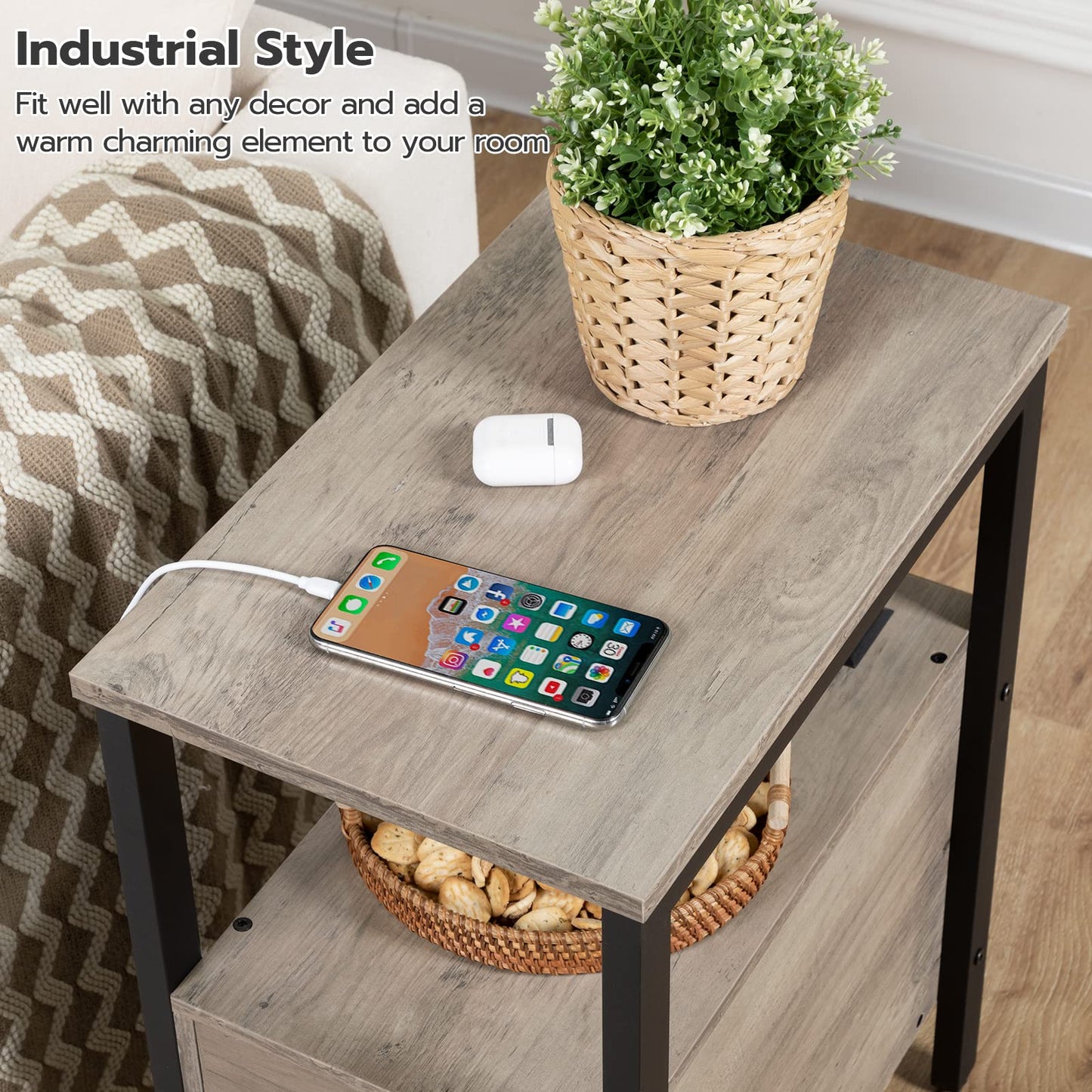 Small wooden table with a smartphone, wireless charger, and plant in a room setting.