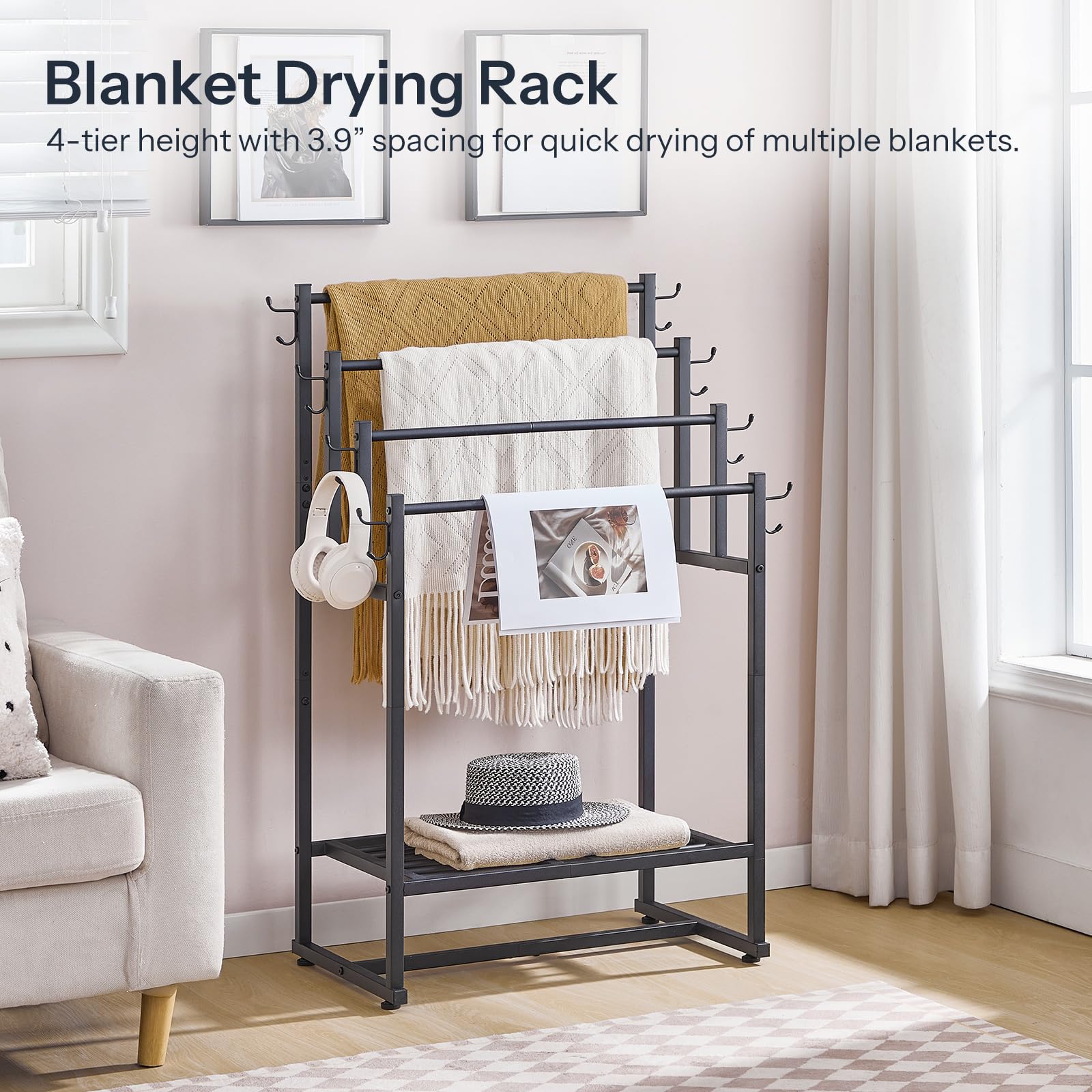 Blanket drying rack with blankets, a hat, and headphones on a stand in a room.