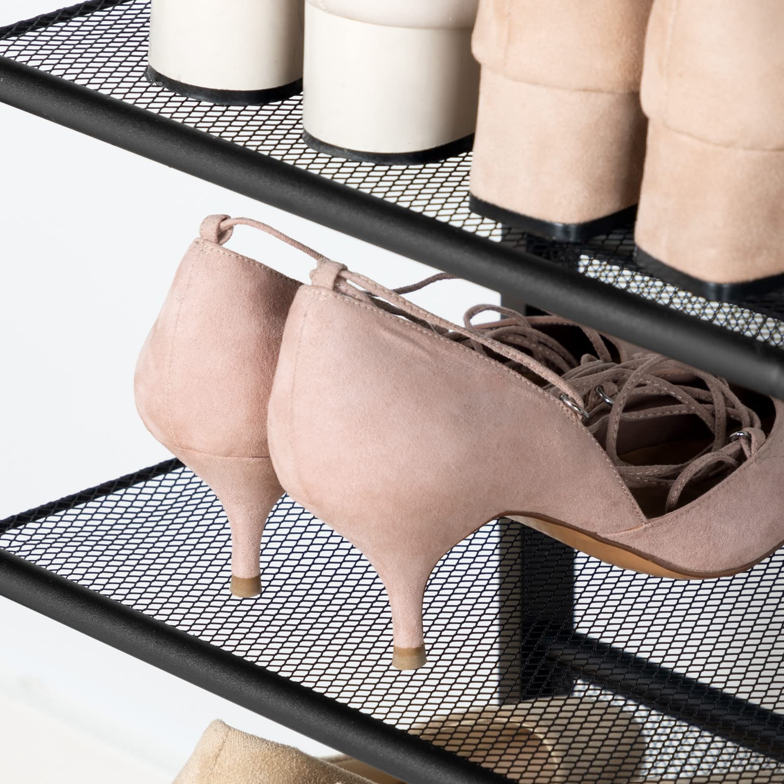 Pair of pink high-heeled shoes on a black mesh shoe rack.