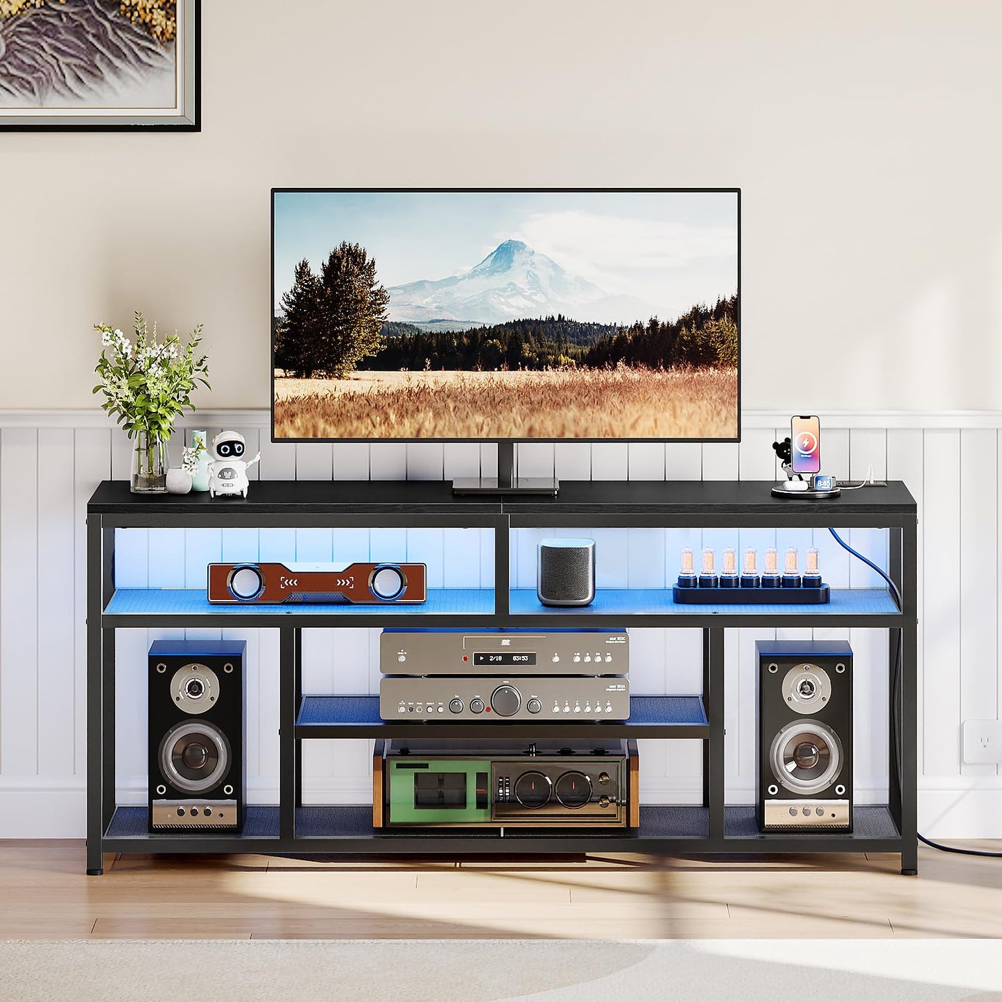 Modern entertainment console with TV, speakers, and decorative items in a living room setting.