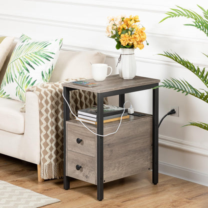 Side table with a vase of flowers, books, and a cup in a living room setting.