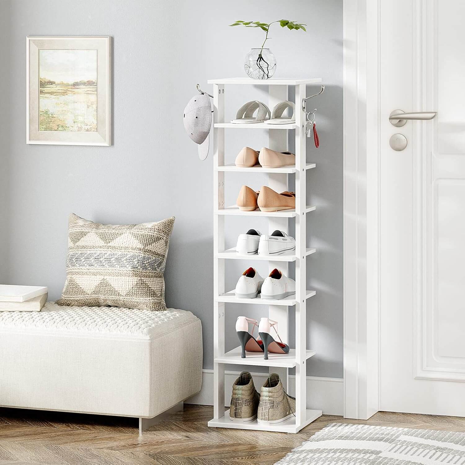 White shoe rack with shoes in a room with a couch and decor