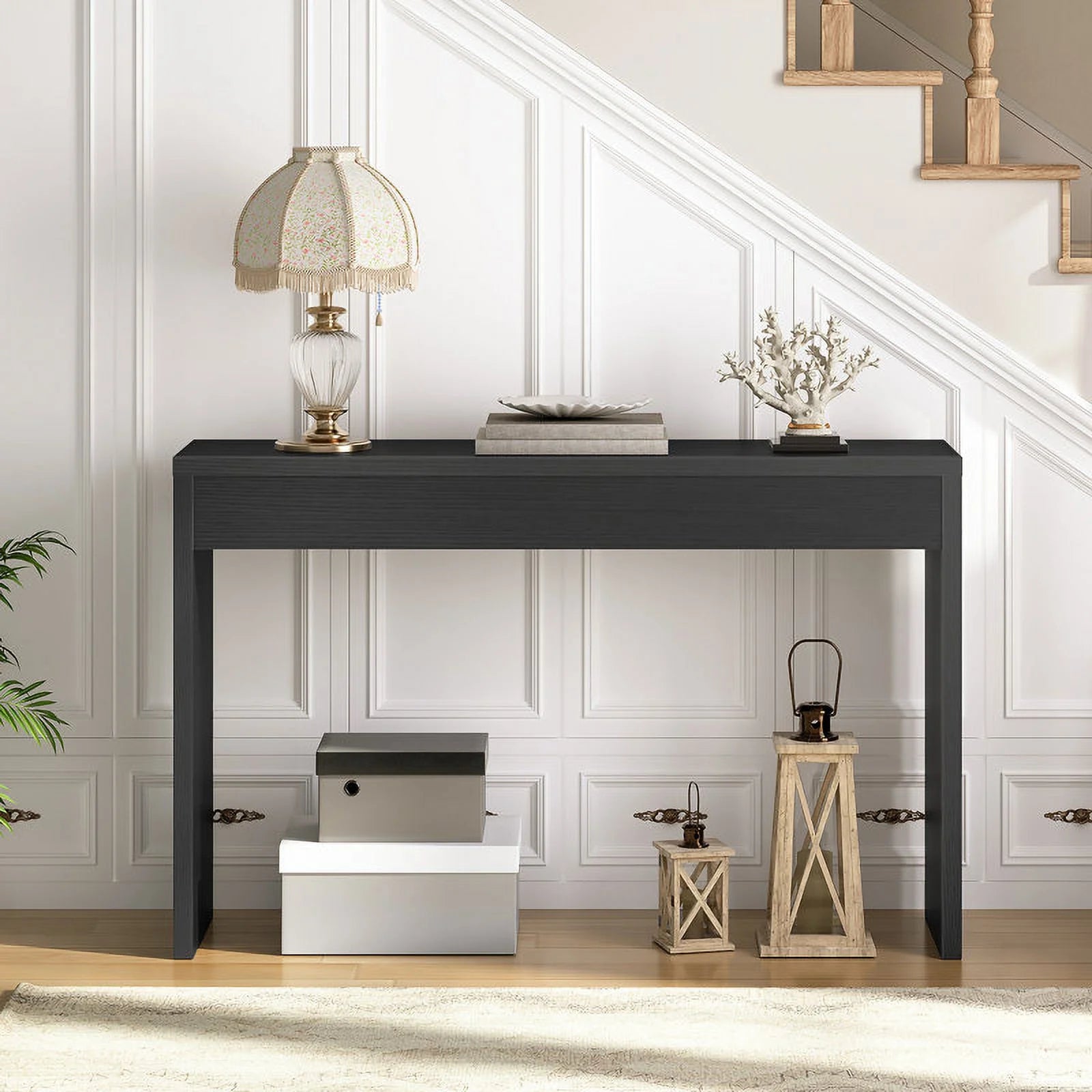 Black console table with decorative items in a stylish interior setting.