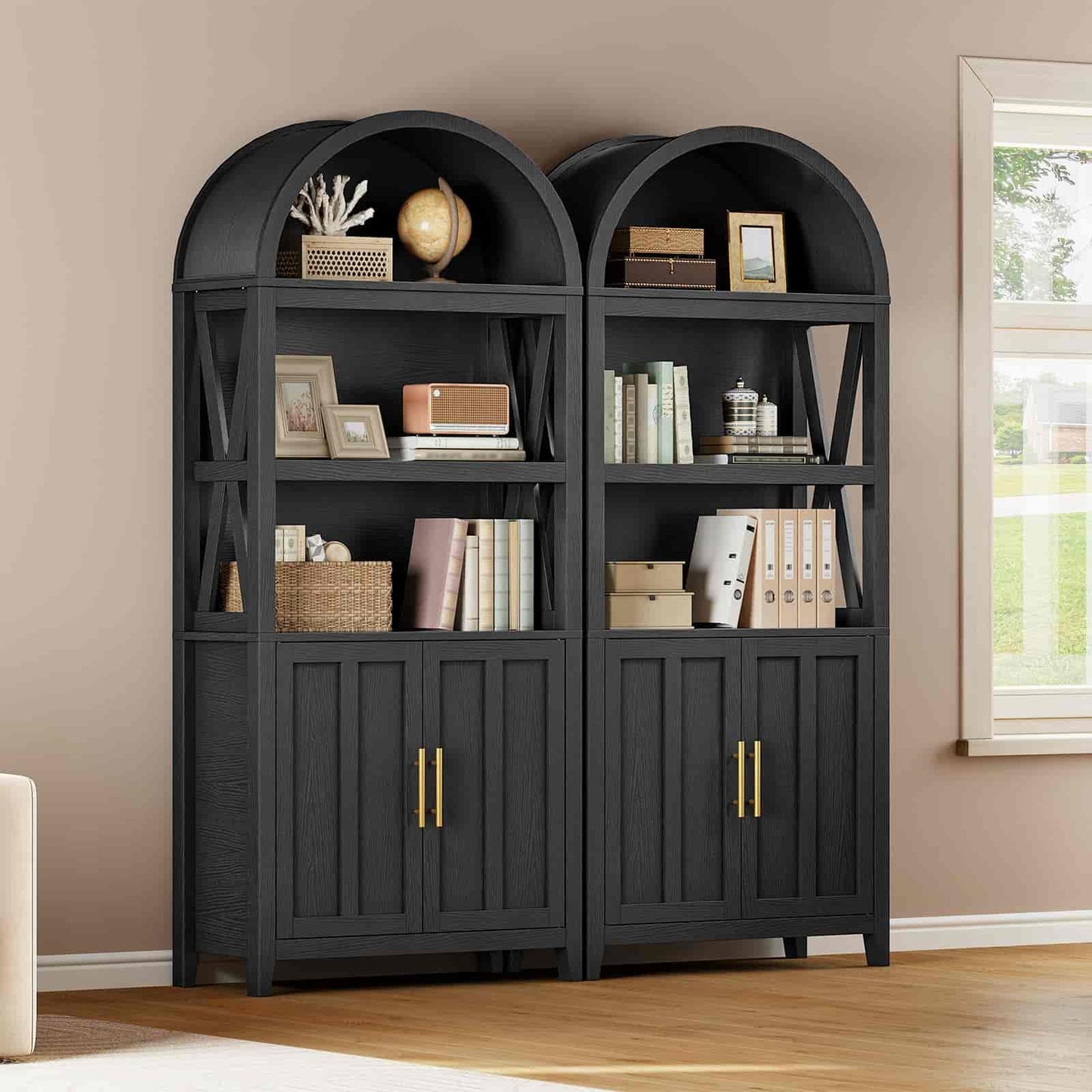 Pair of black bookshelves with decorative items against a beige wall.