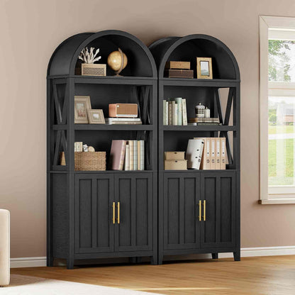 Pair of black bookshelves with decorative items against a beige wall.