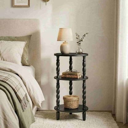 Black spiral nightstand with lamp and books next to a bed in a bedroom.