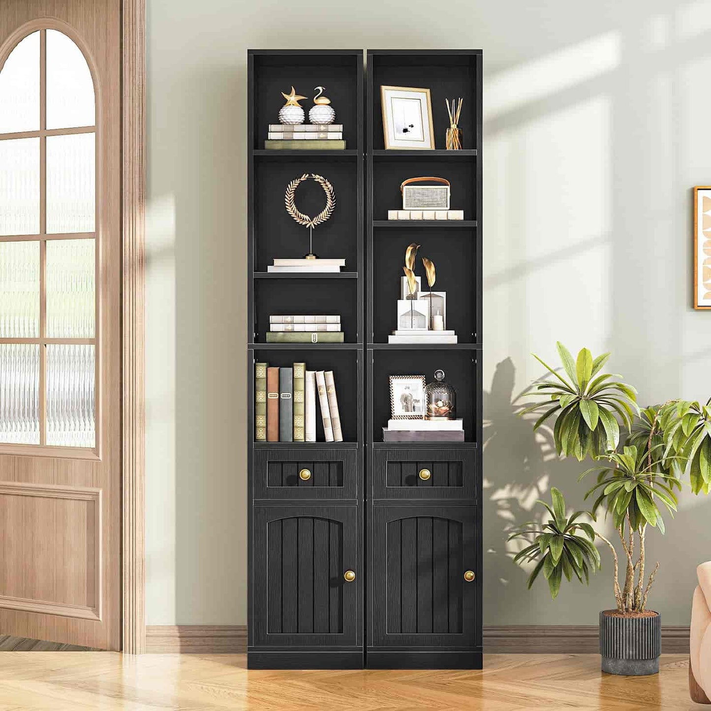 Black bookshelf with decorative items in a room with plants and a wooden door.