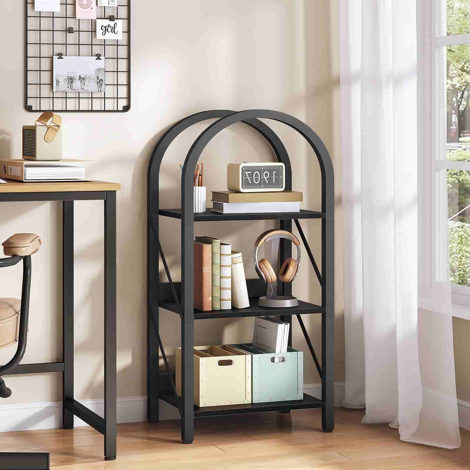 Black metal bookshelf with decorative items in a room with a desk and window.