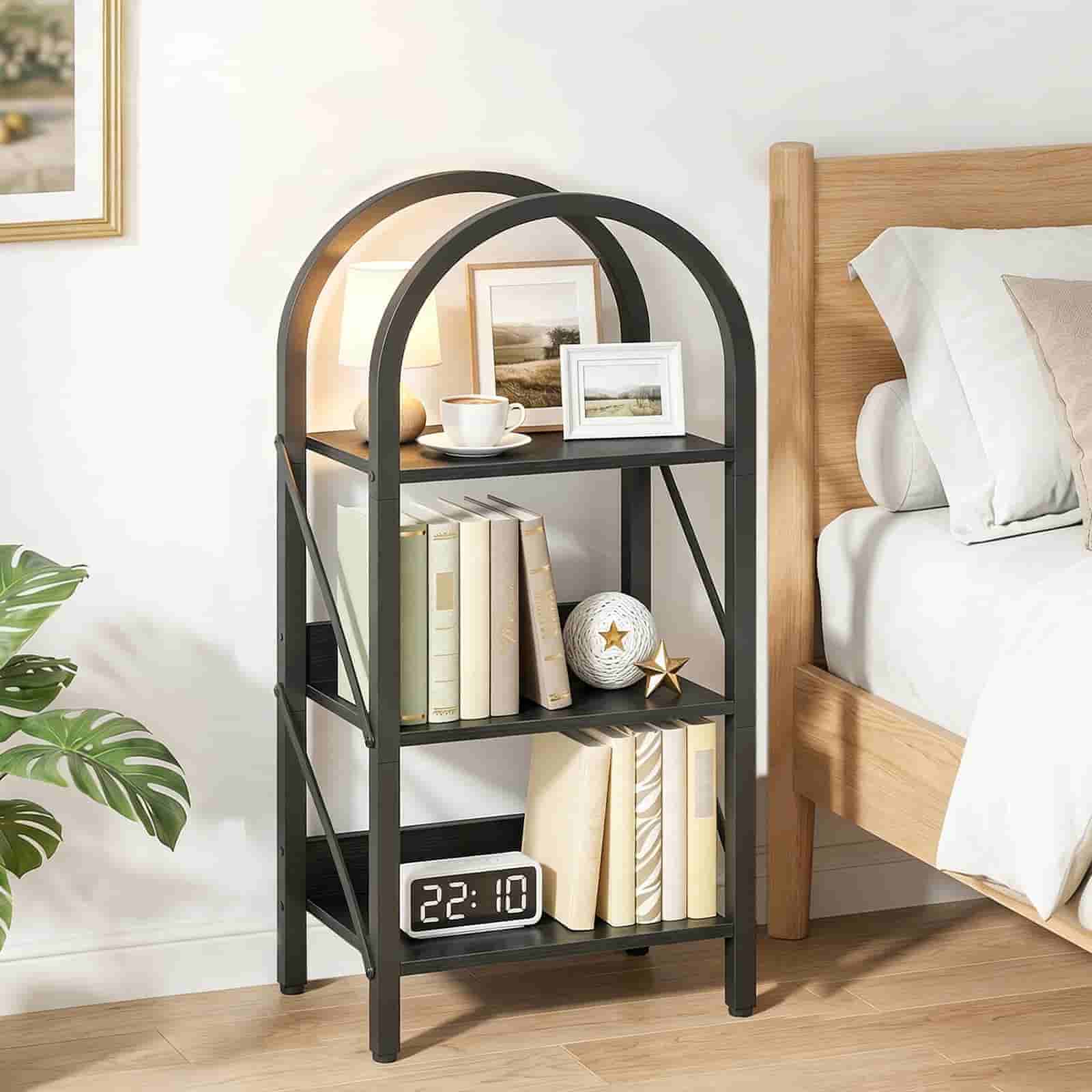 Black metal bookshelf with books and decor items in a bedroom setting.