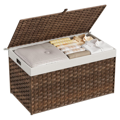Wicker storage chest with white interior containing folded clothes on a white background