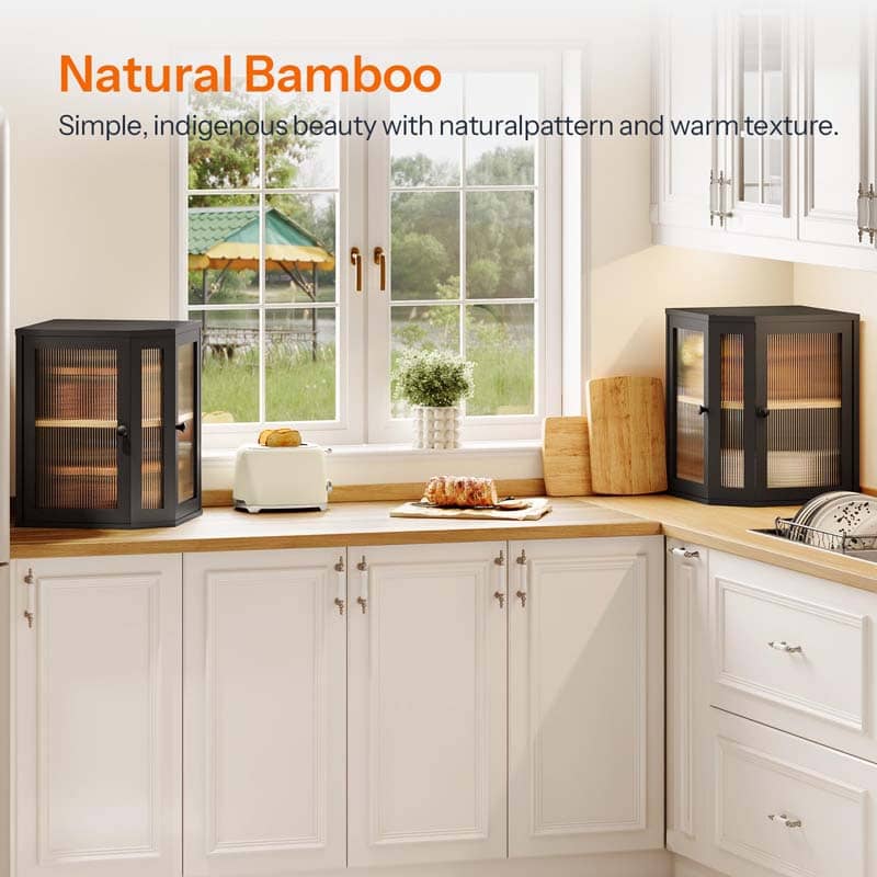 Two black-framed bamboo wood display cabinets with glass doors shown in a bright, modern kitchen setting. The cabinets are styled on a wooden countertop next to a window, with a toaster, bread, and decorative items nearby.