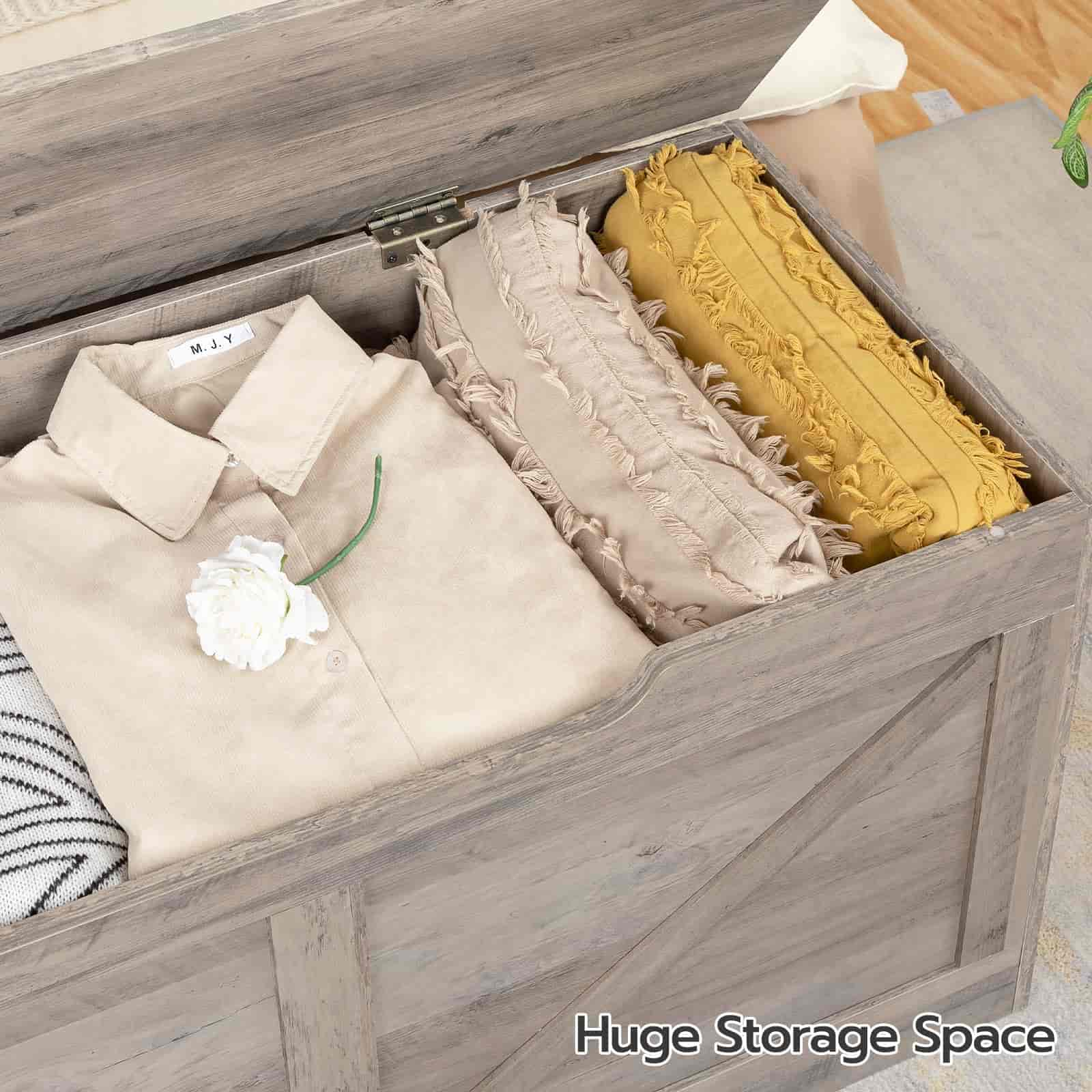 Wooden storage box with clothes and pillows labeled 'Huge Storage Space'.