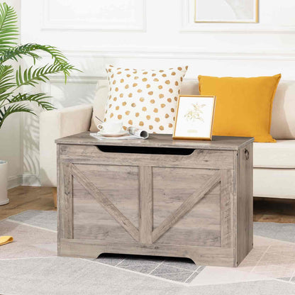Wooden storage bench in a living room with decorative pillows and a plant.