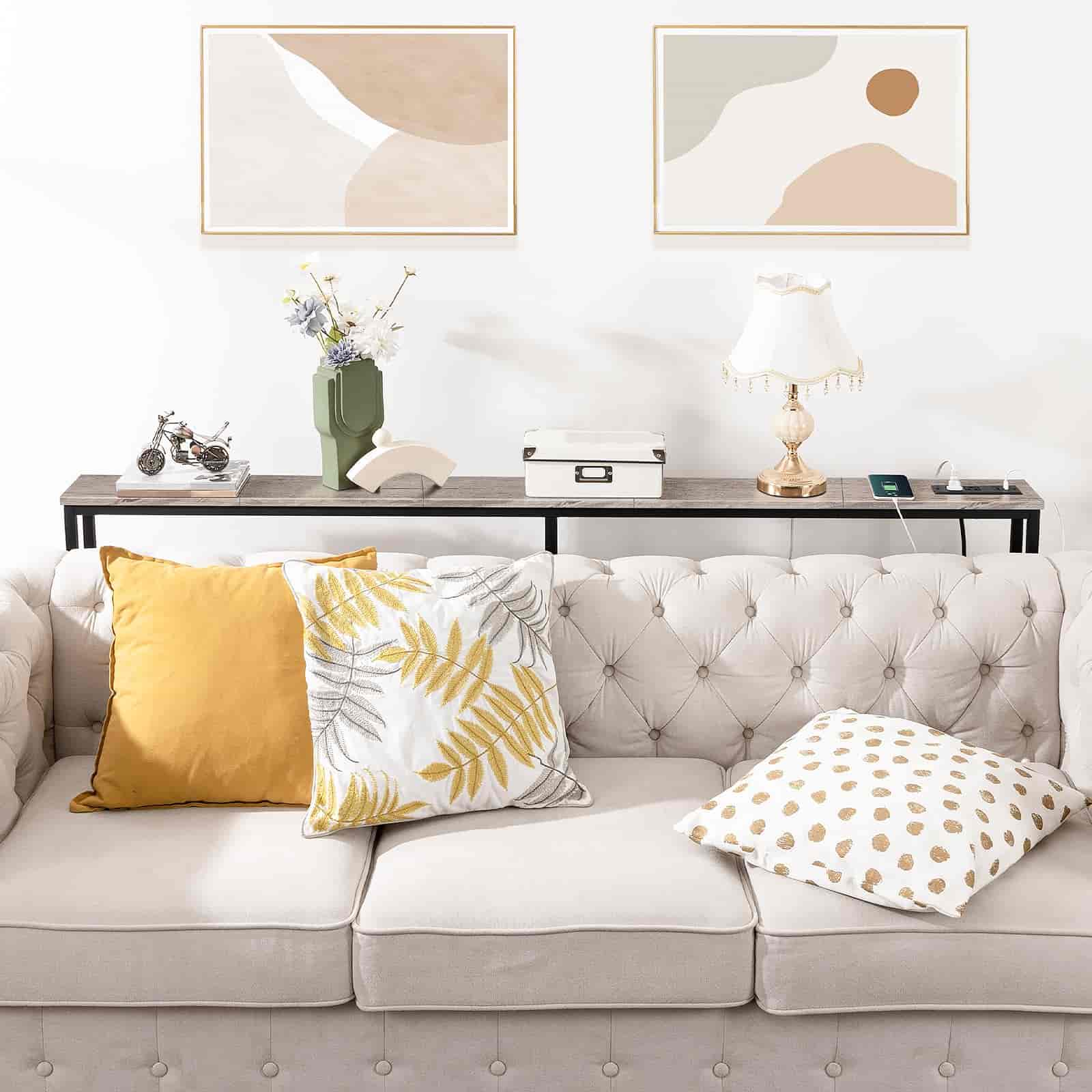 Living room with a gray sofa, decorative pillows, and abstract art on the wall.