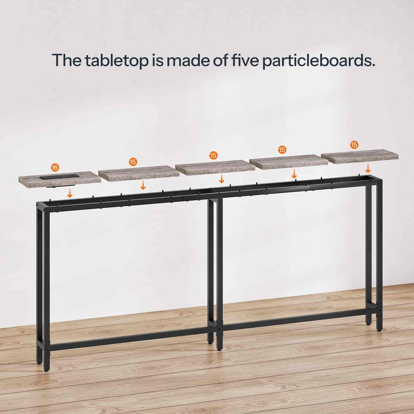 Long black metal table with particleboard tabletop sections on a wooden floor.