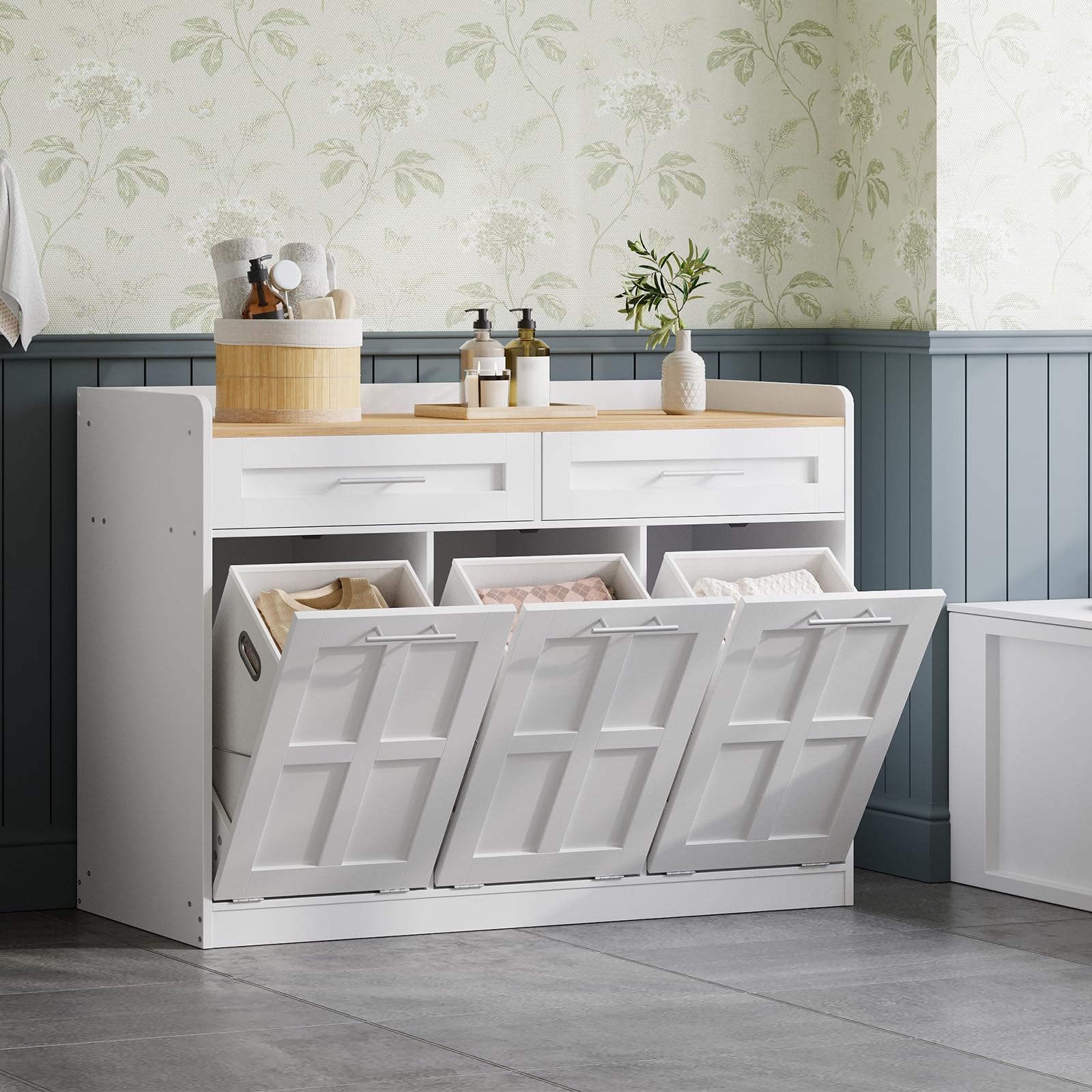 White laundry sorting bin with three compartments in a room with floral wallpaper.