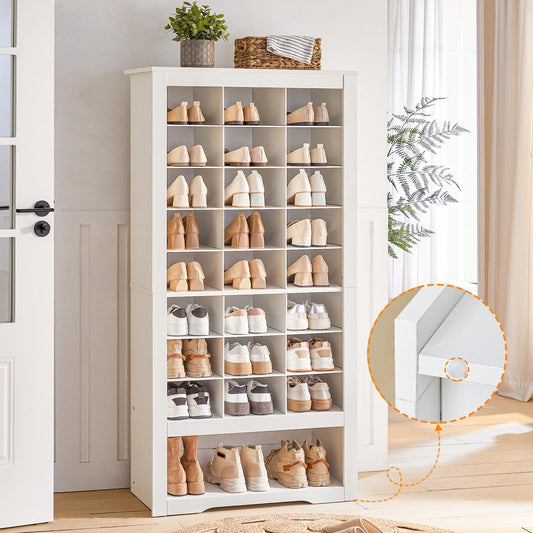 White shoe cabinet with various shoes on shelves in a room with a door and plants.