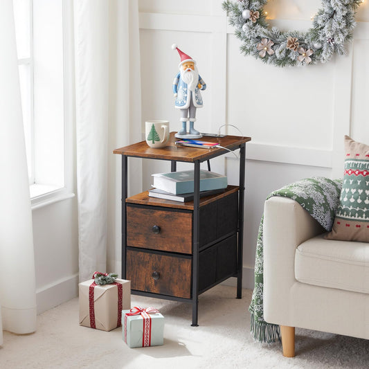 Small wooden side table with festive decor including a Santa figure, books, and wrapped gifts in a cozy living room.
