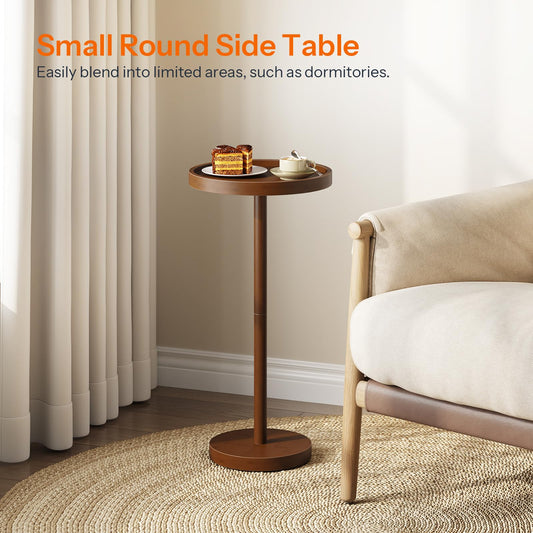 Small round side table in a living room setting with a couch and curtains.