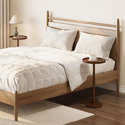 Wooden bed with white bedding and pillows in a room setting.