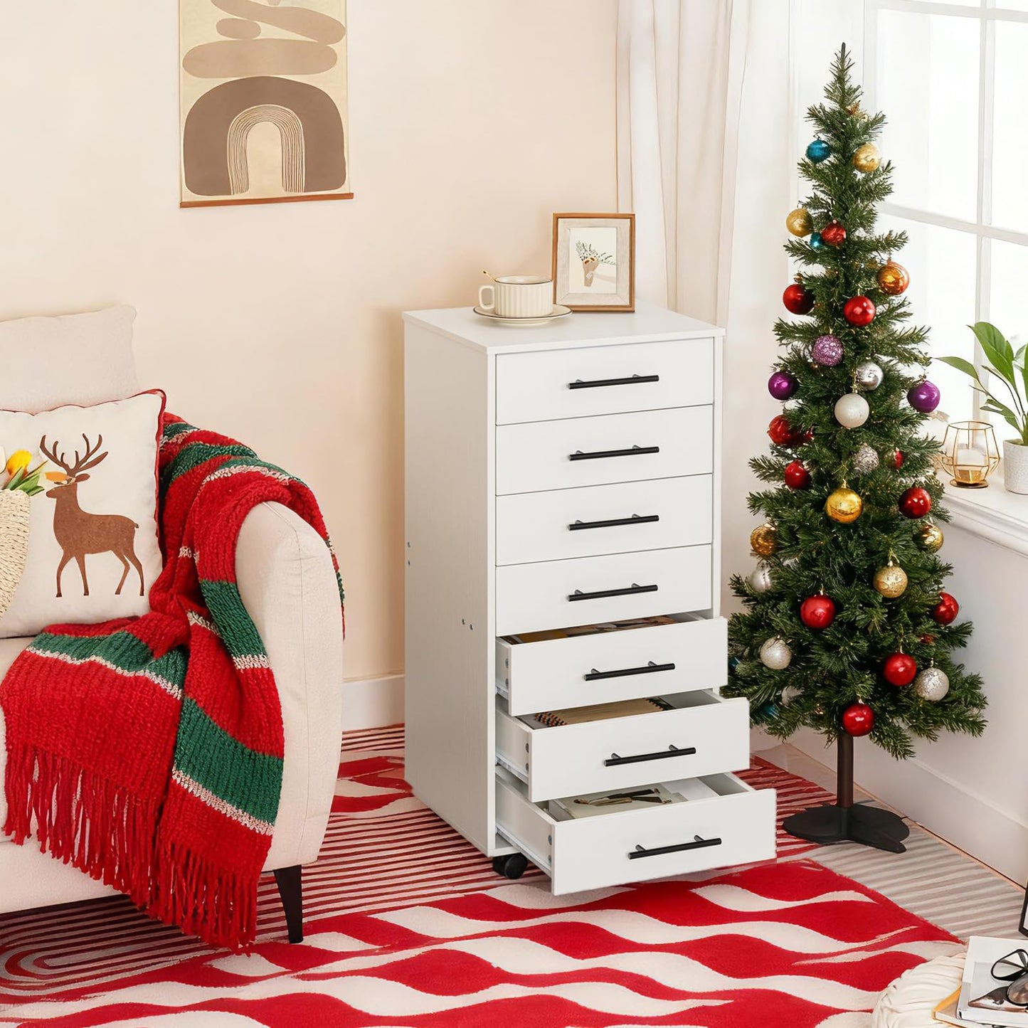 White storage cabinet with drawers next to a decorated Christmas tree in a living room.