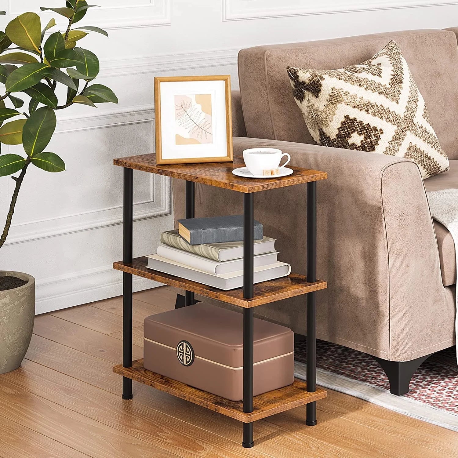 Wooden side table with books and a cup next to a brown sofa in a living room.