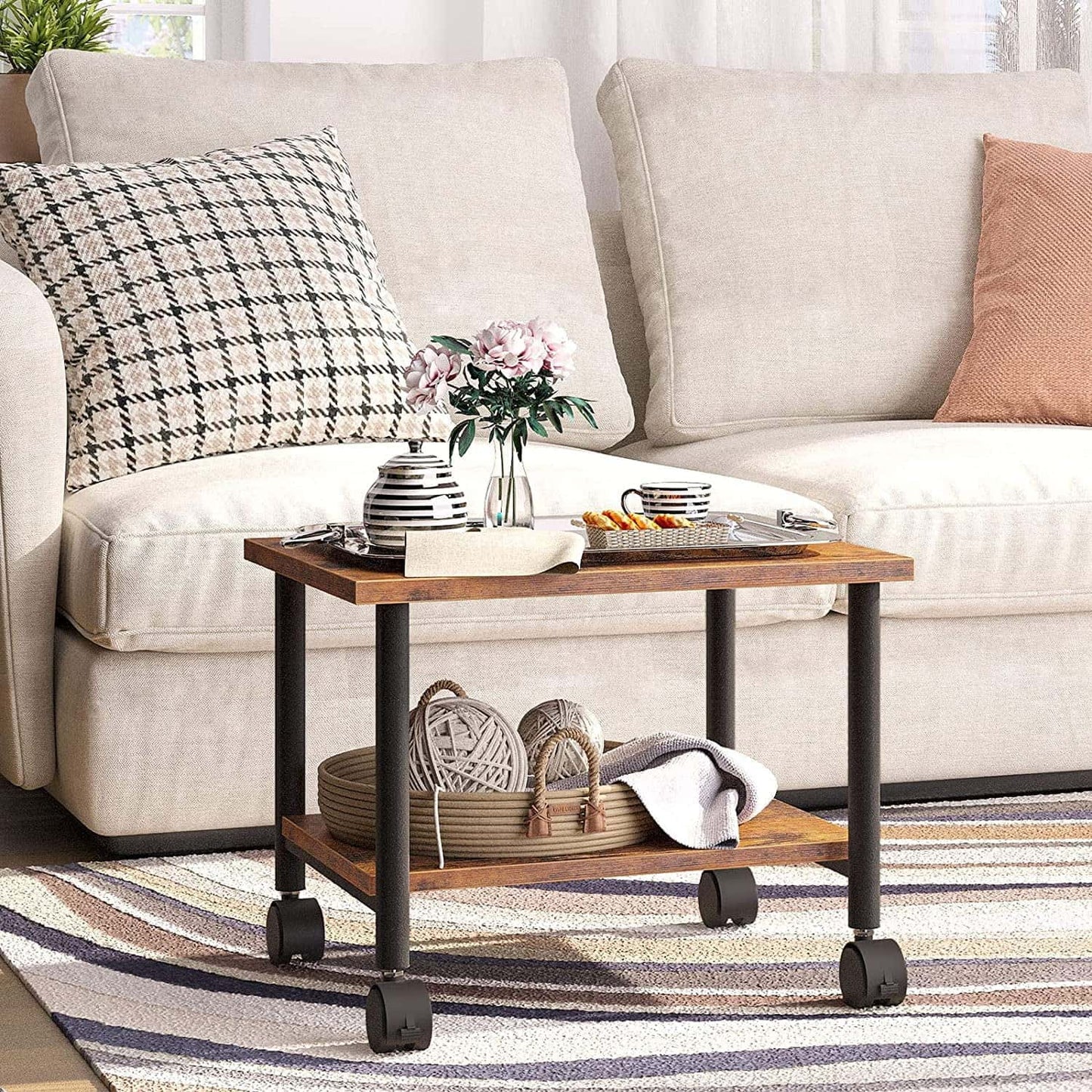Wooden side table with wheels in front of a beige sofa with decorative pillows.