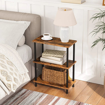 Wooden nightstand with books, a cup, and a lamp next to a bed in a bedroom.