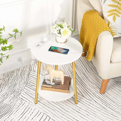 Small round white table with gold legs next to a beige armchair with a yellow blanket and plant.