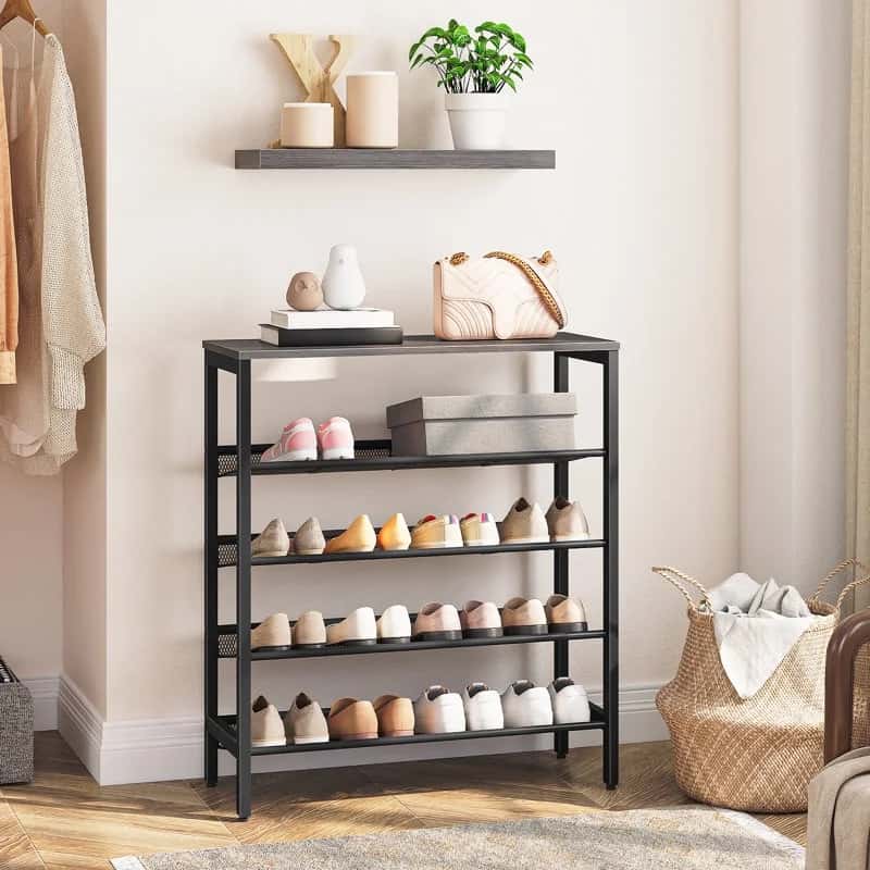 Black shoe rack with shoes on shelves in a room setting.