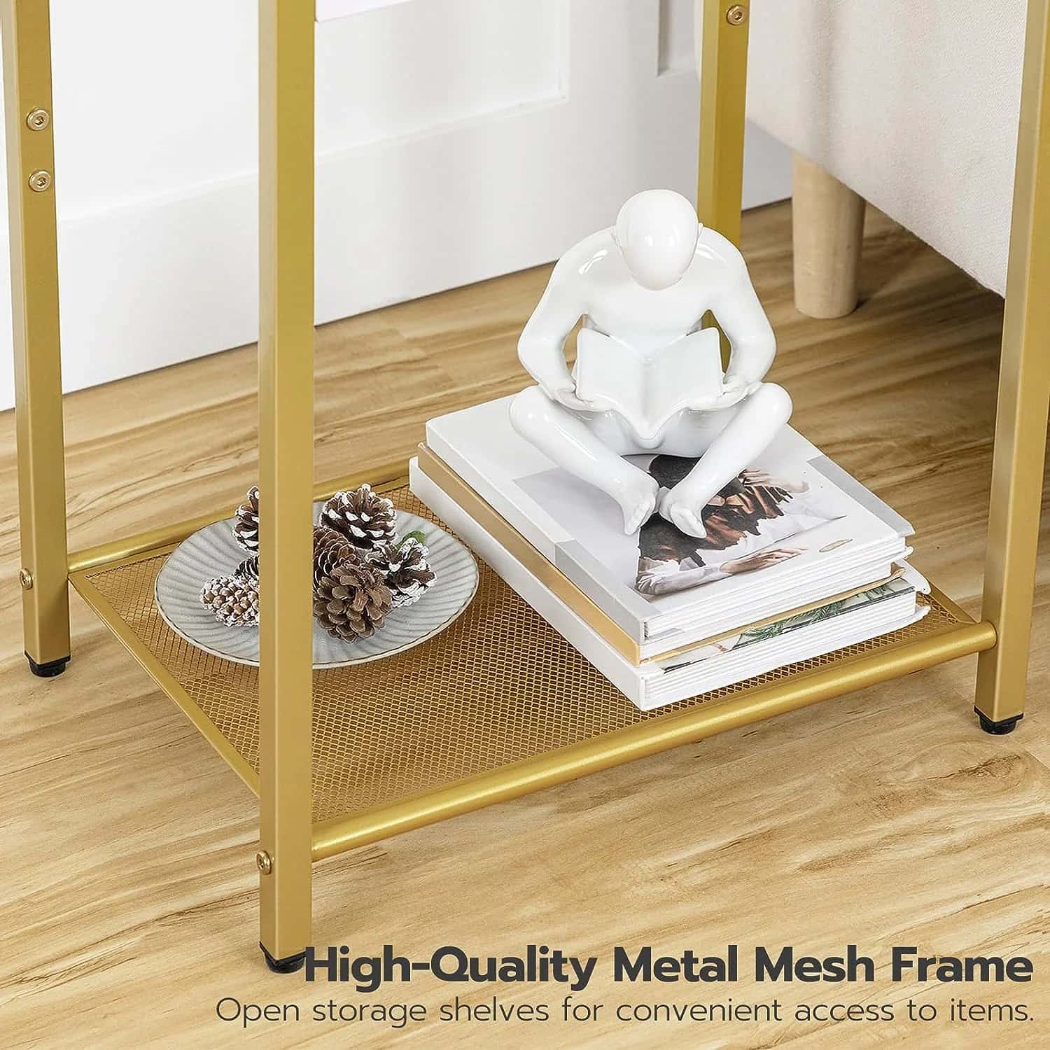 Gold metal mesh shelf with books, decorative items, and a sculpture on a wooden floor.