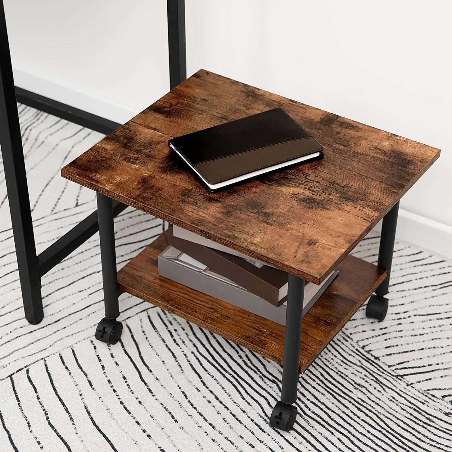 Wooden side table with black metal legs on a patterned rug