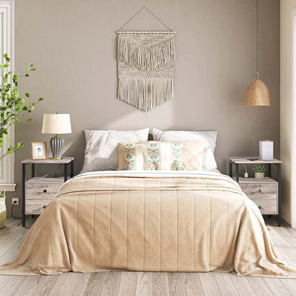 Neatly made bed with beige bedding in a bedroom setting.